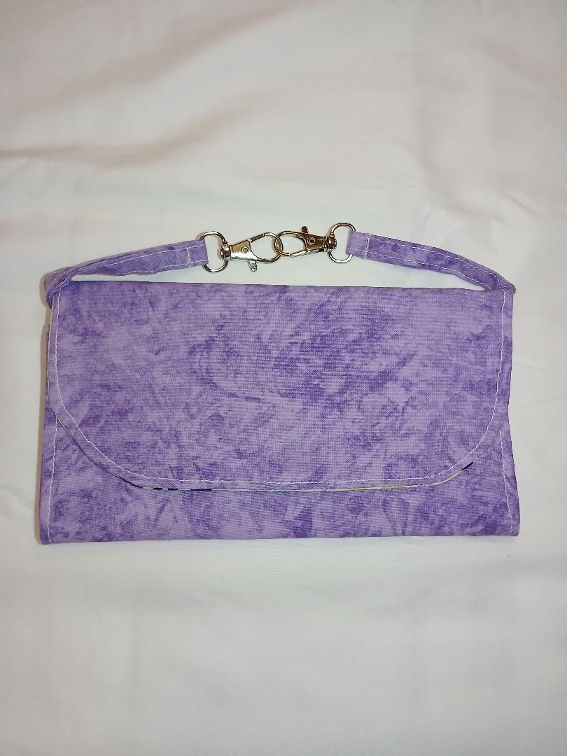 Purple fabric pouch with a white strap and clasp on a light background