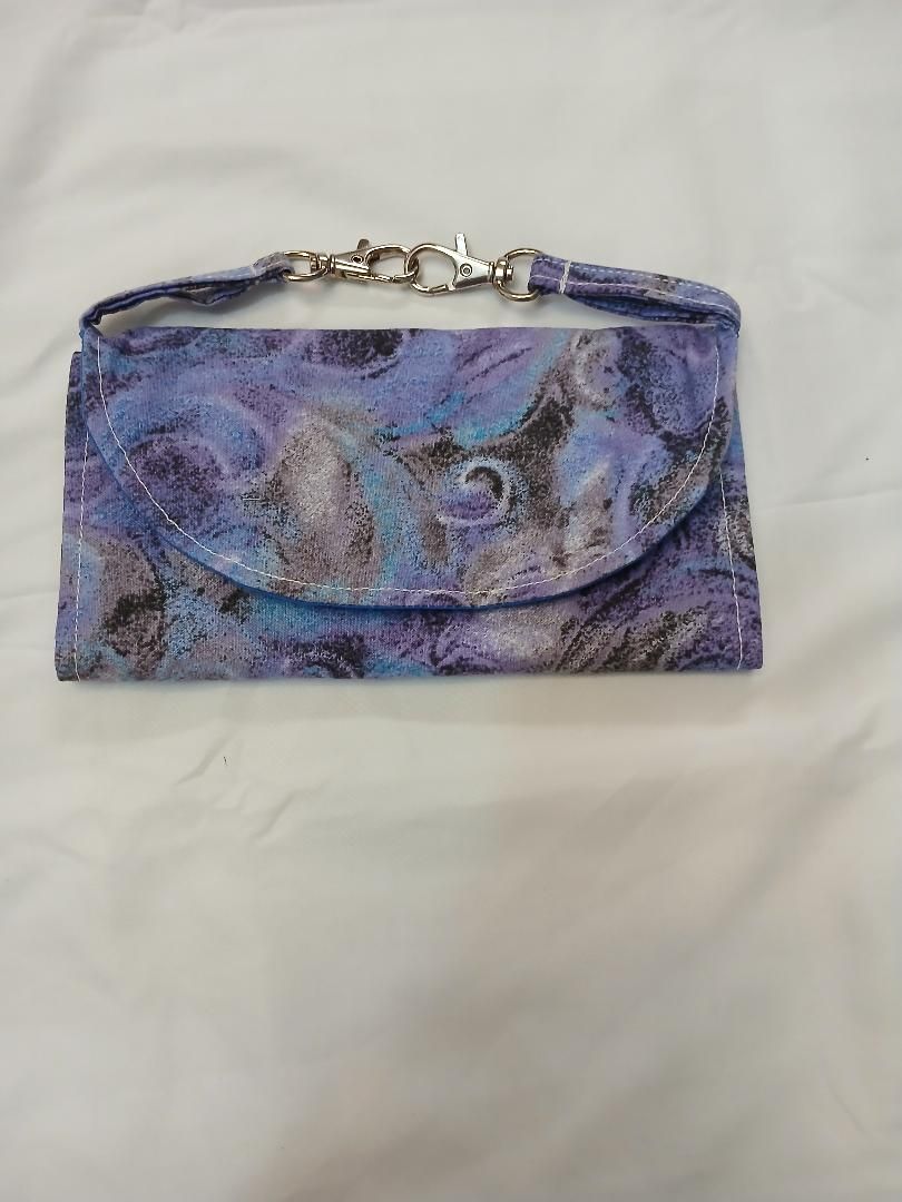 Purple and blue patterned zippered pouch with a metal chain strap on a white background