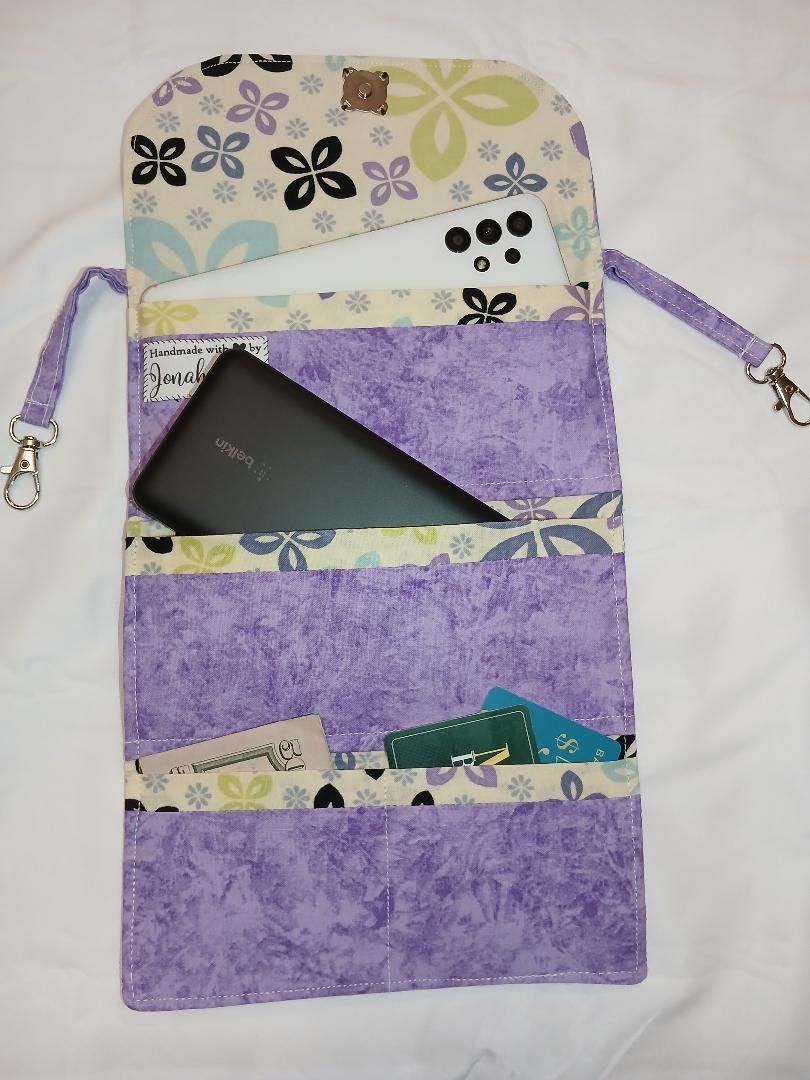 Purple floral hanging organizer with zip pocket and open compartments holding papers and a black notebook