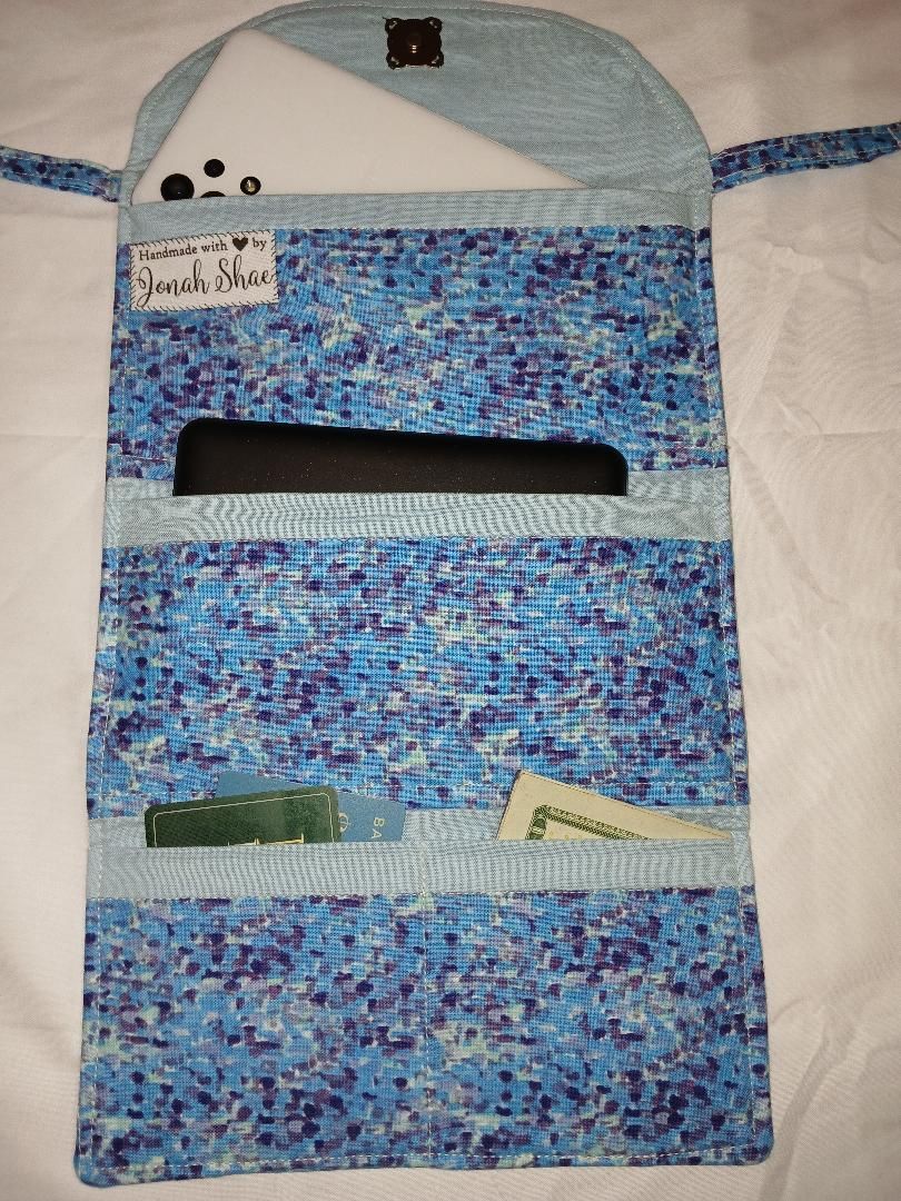 Blue patterned hanging organizer with several pockets and papers inside