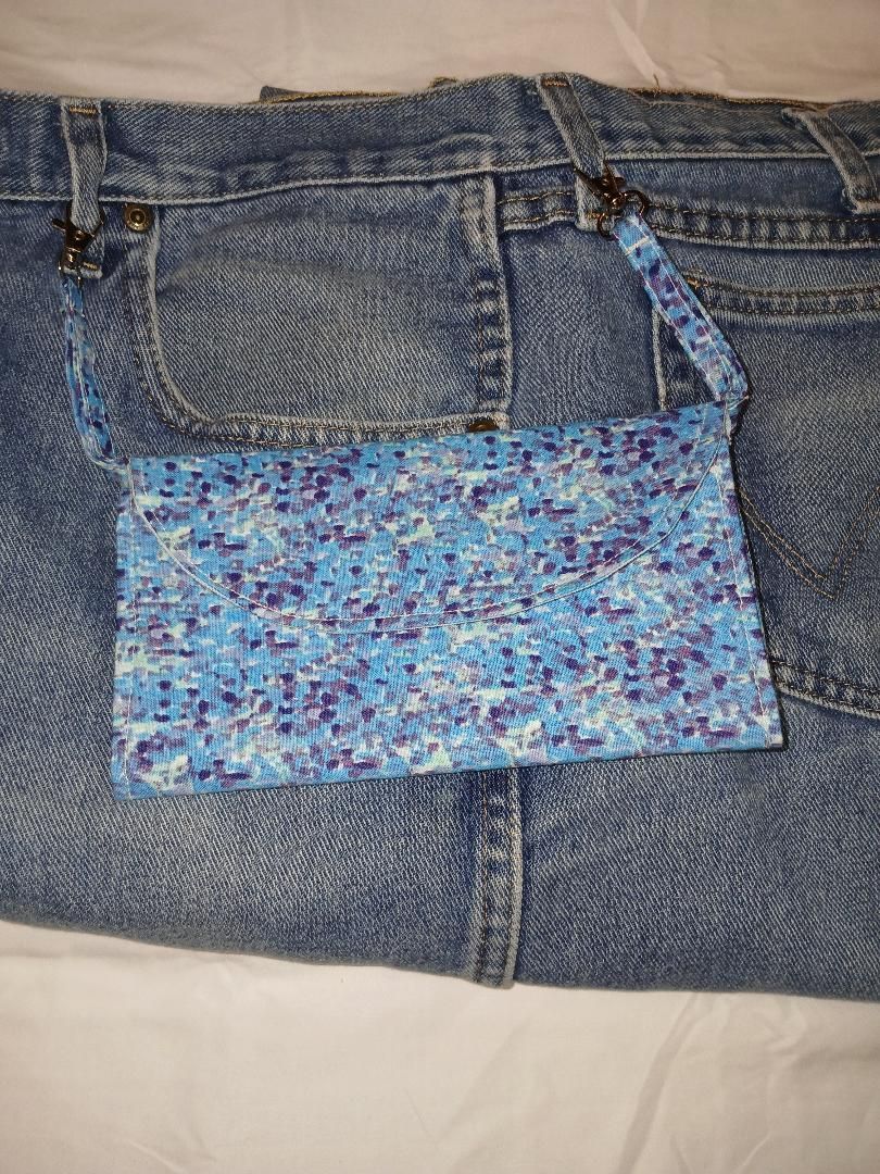 Blue denim jeans with a floral-patterned patch sewn onto the back pocket area