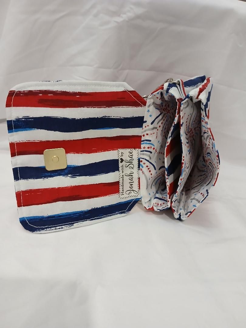 Red, white, and blue striped small bag with ruffled side view and a tan button clasp