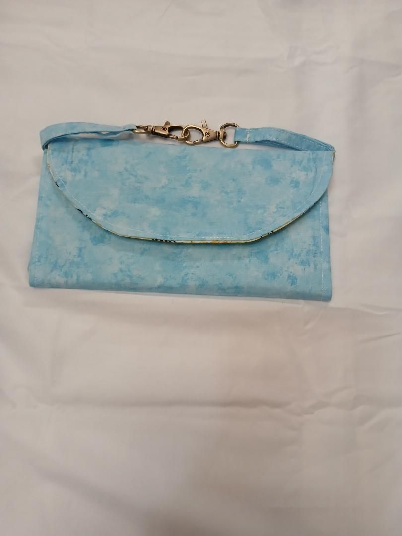 Light blue handbag with a flap and gold clasp on a white background