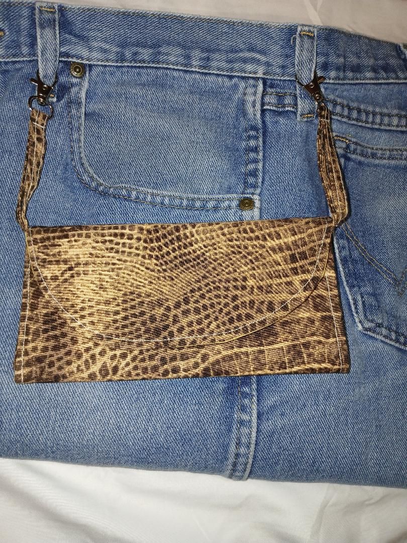 Blue jeans with a small leopard-print pouch attached near the pocket.