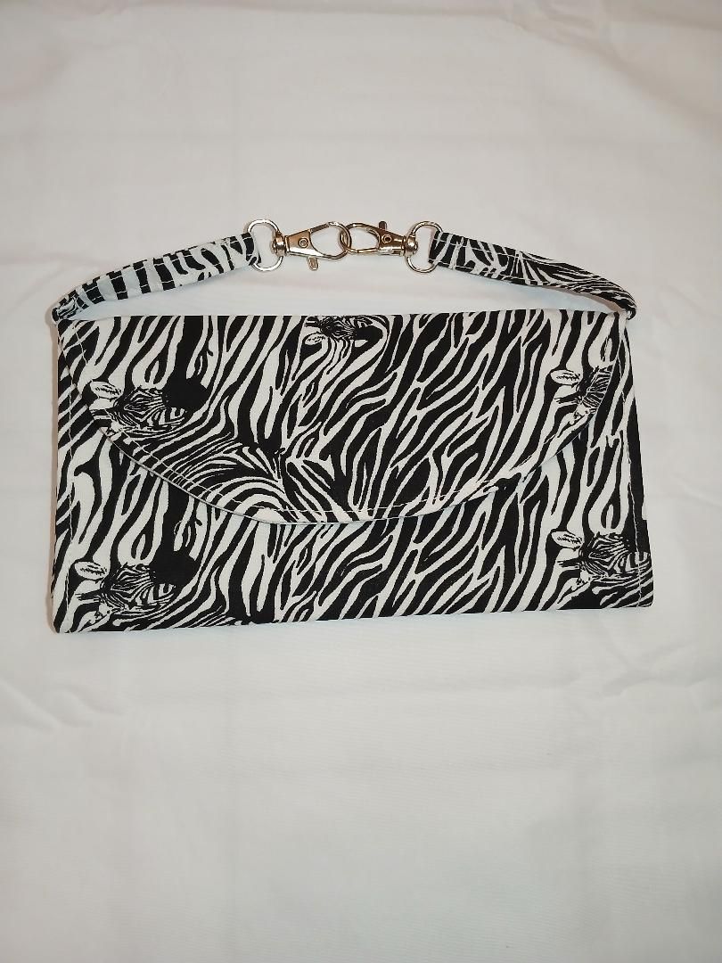Black-and-white zebra-print handbag with silver chain handle on a white background