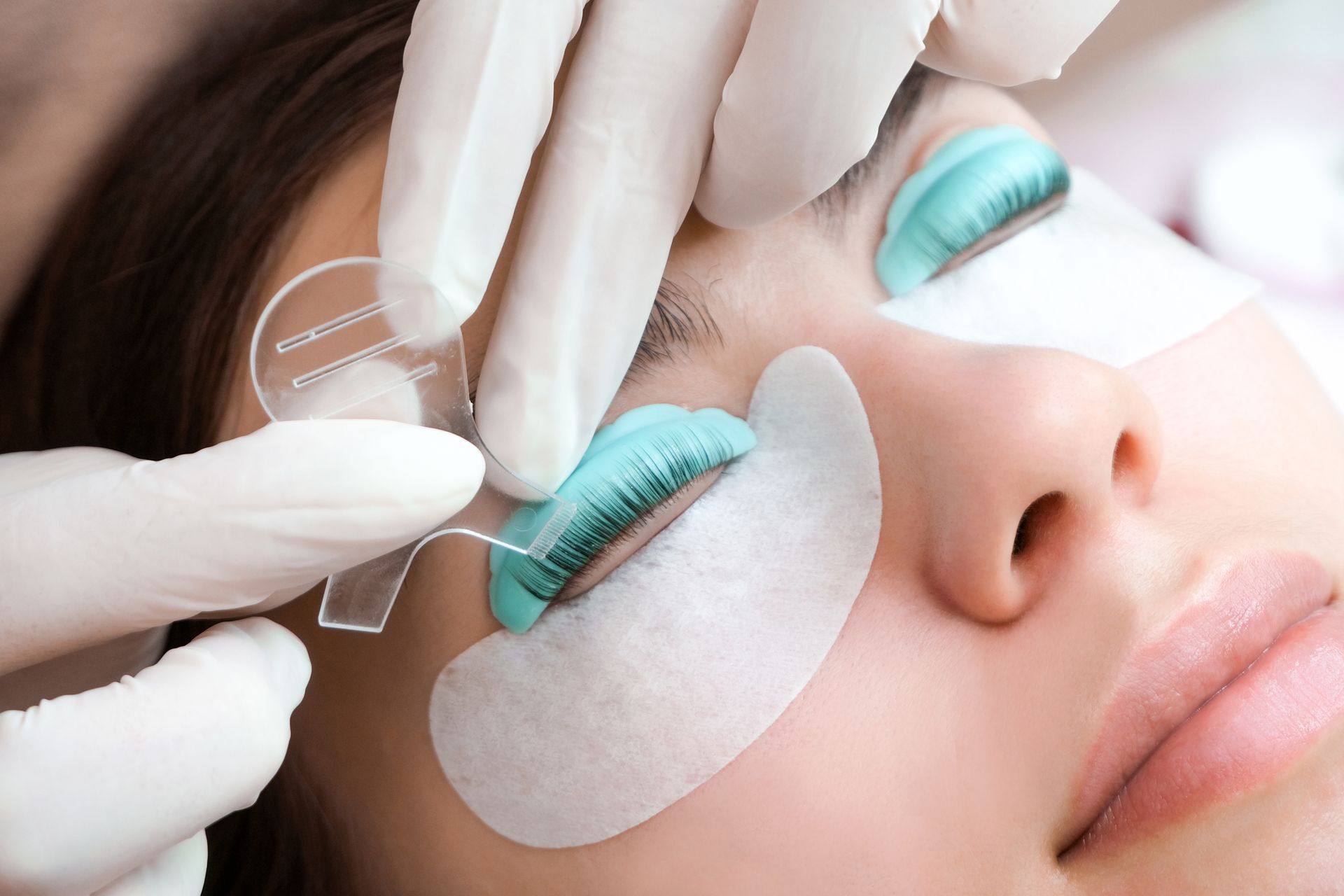 Close-up of a person's face, eye being treated during an eyelash lift procedure.
