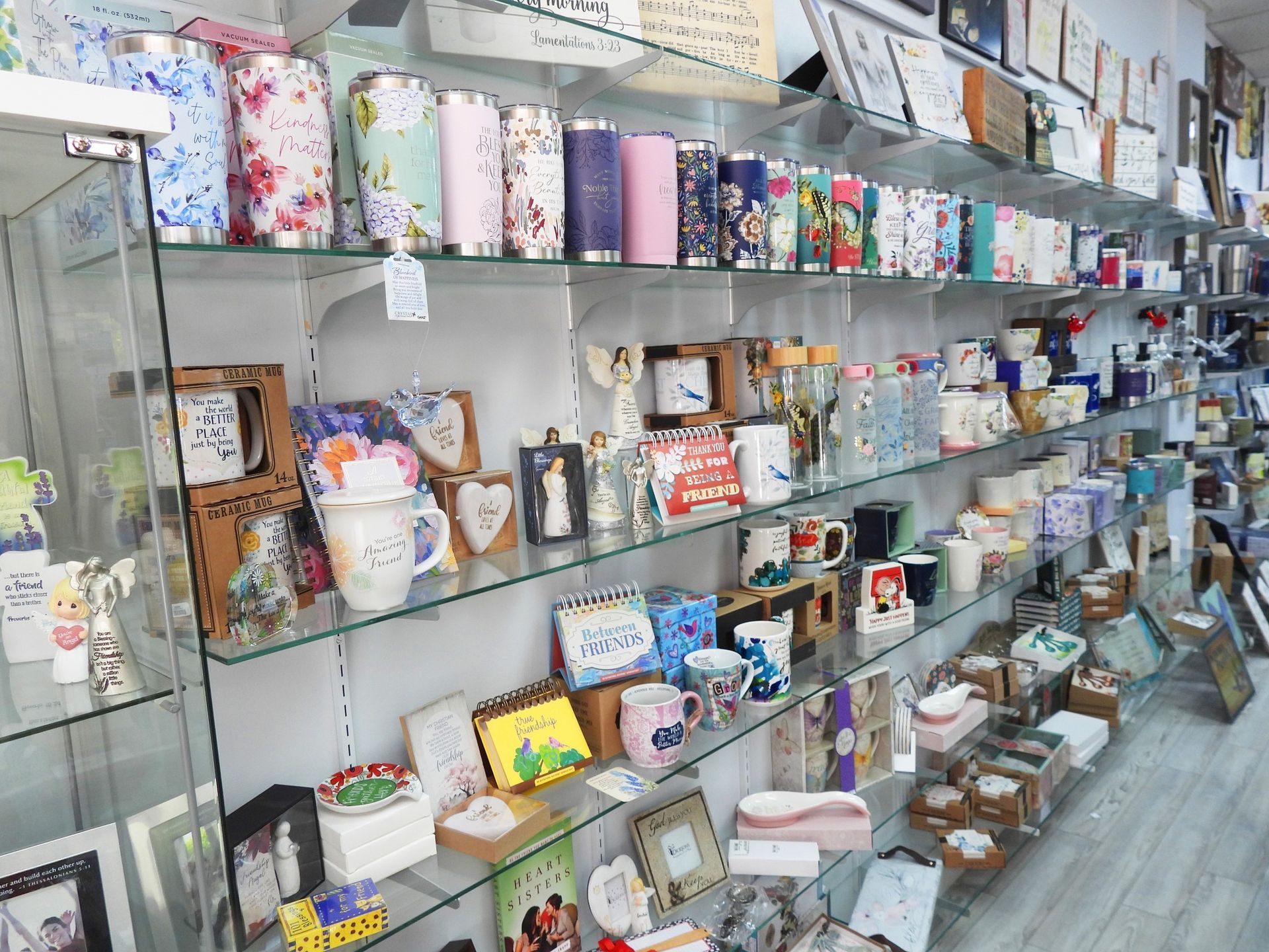 Shelves of mugs, tumblers, and gifts in a brightly lit retail store.
