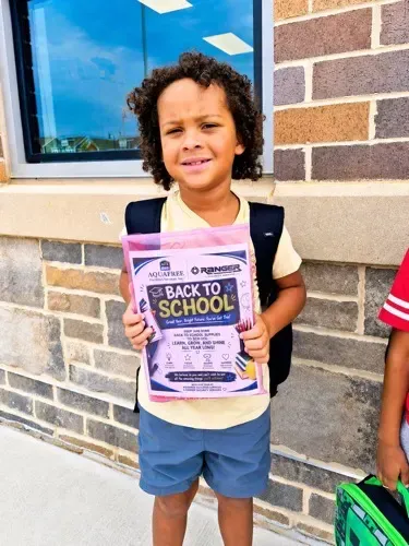 young girl with back to school backpacks from AquaFree Facilities Services.