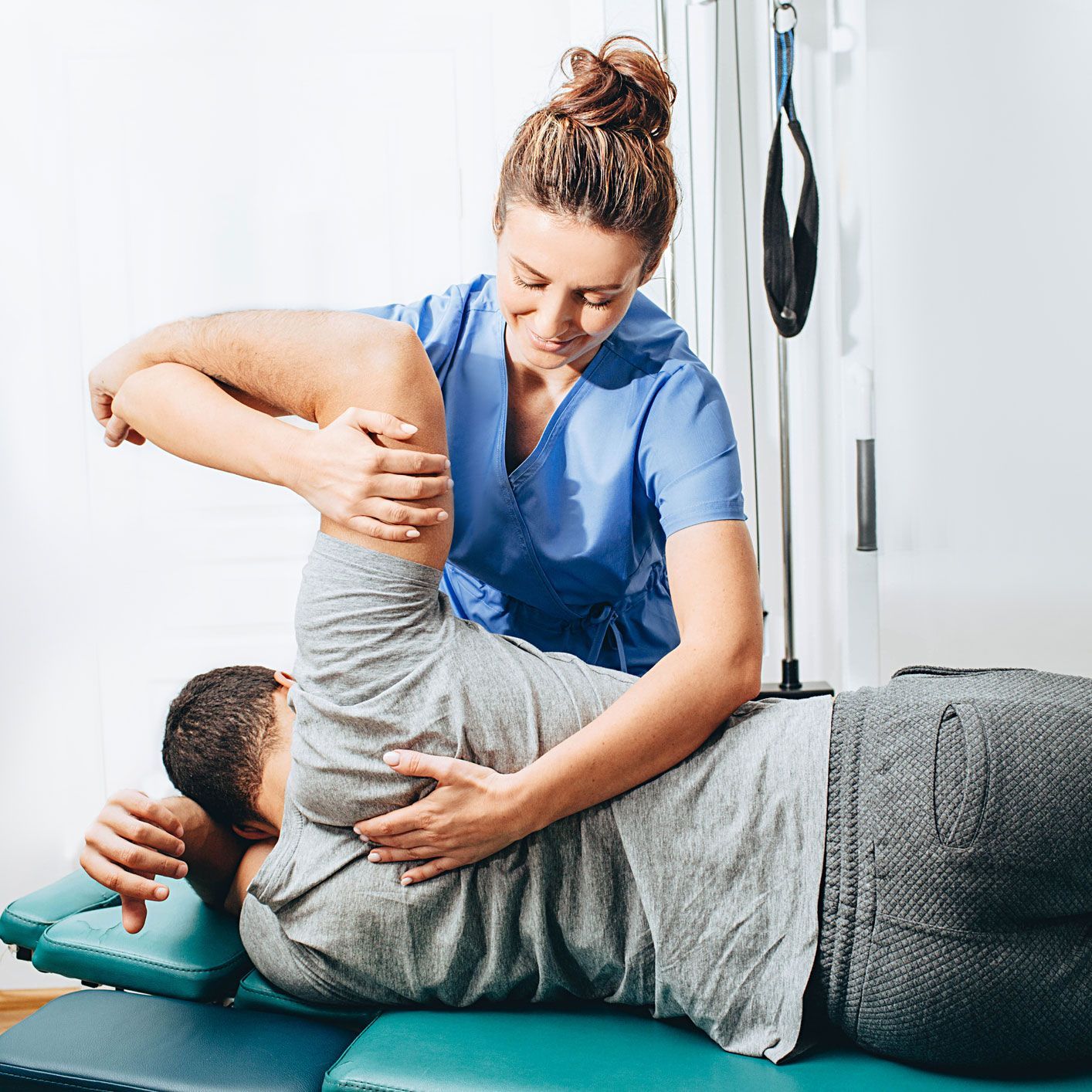 A Woman Is Stretching a Man's Leg on A Table — Marlton, NJ — Luna Lymphatic Care
