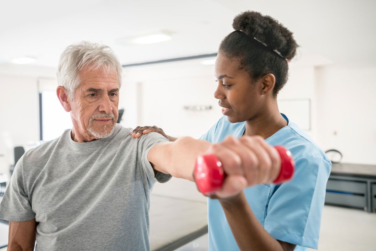 A Nurse Is Helping an Older Man Lift a Dumbbell — Marlton, NJ — Luna Lymphatic Care