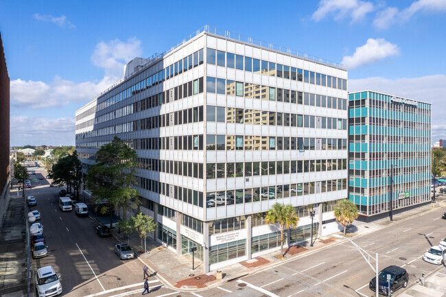 Modern multi-story office buildings with numerous windows in an urban setting.