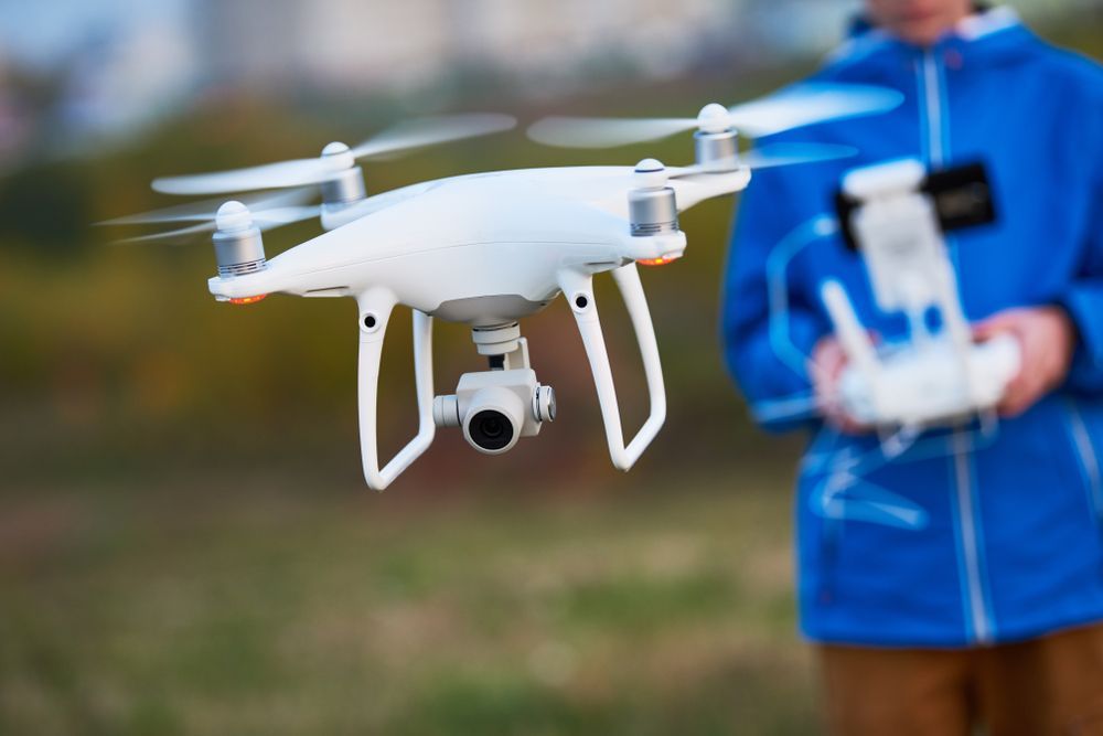 White Drone in Mid-air a Person Holding the Remote Control — NQ Video Surveillance in Townsville, QLD