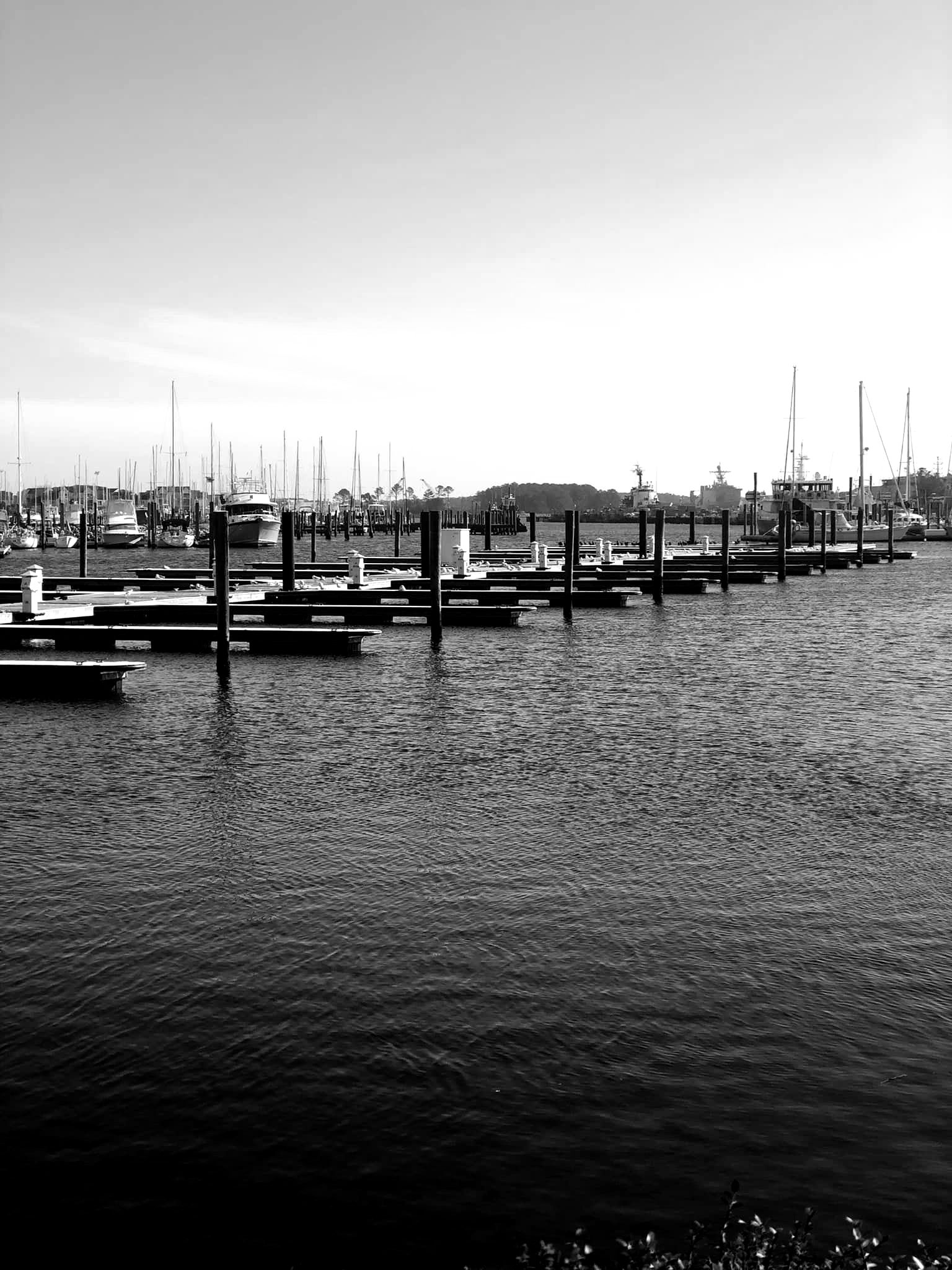 A black and white photo of a marina with boats docked