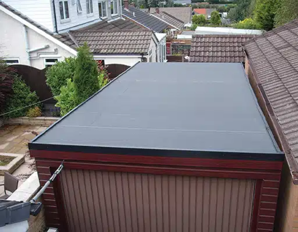 Flat gray roof cover on a backyard shed between neighboring houses