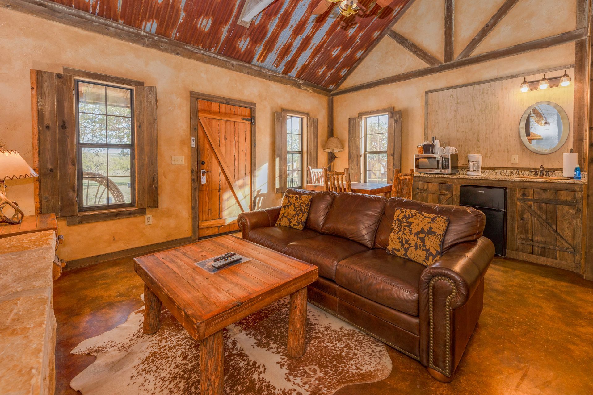 Cozy cabin interior with leather sofa, wooden furniture, and rustic accents.