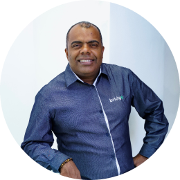 Um homem vestindo uma camisa azul uniforme Bridge Gestão Social 