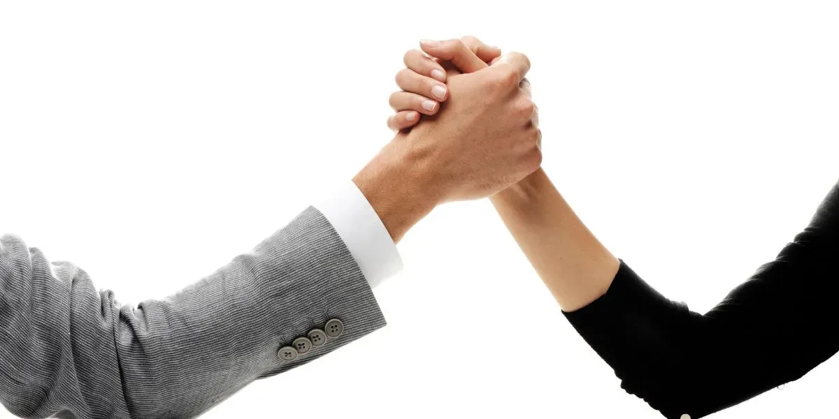 duas pessoas em queda de braço para representa conflitos empresariais