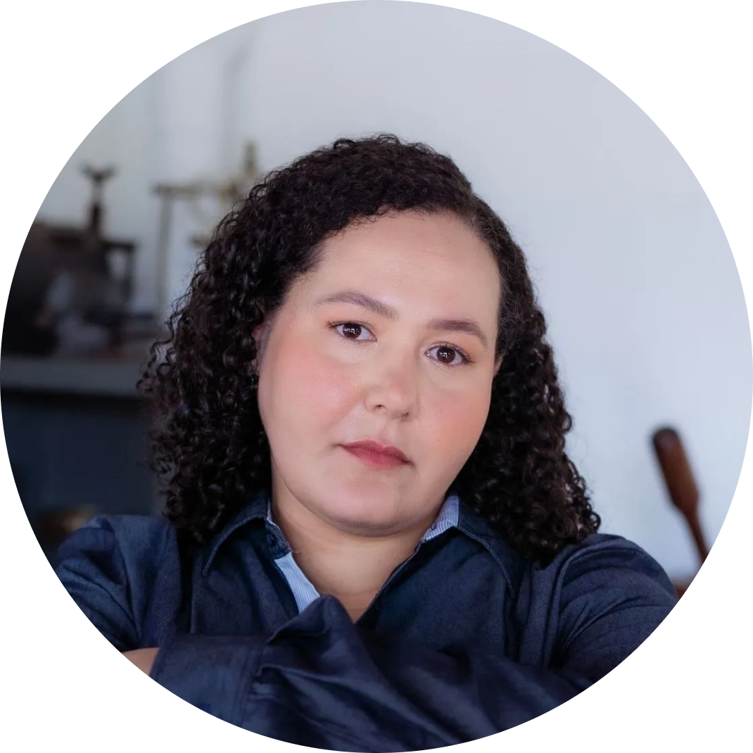 Uma mulher com cabelo cacheado e uma camisa azul uniforme Bridge Gestão Social