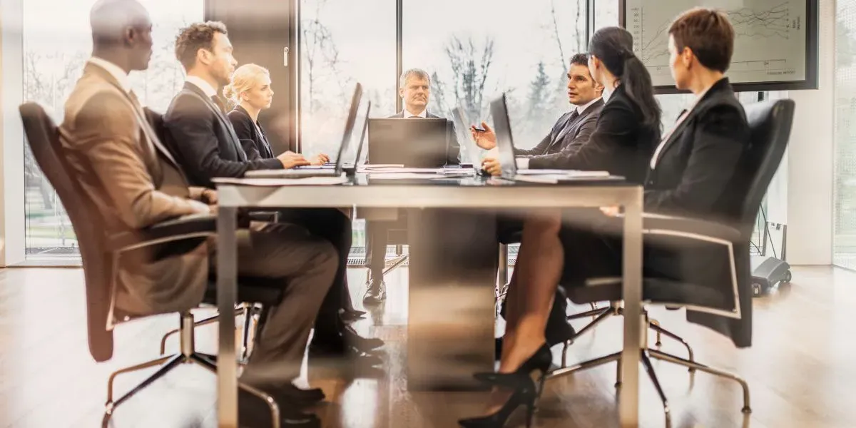 pessoas conversando em uma mesa de escritório representando a comunicação empresial