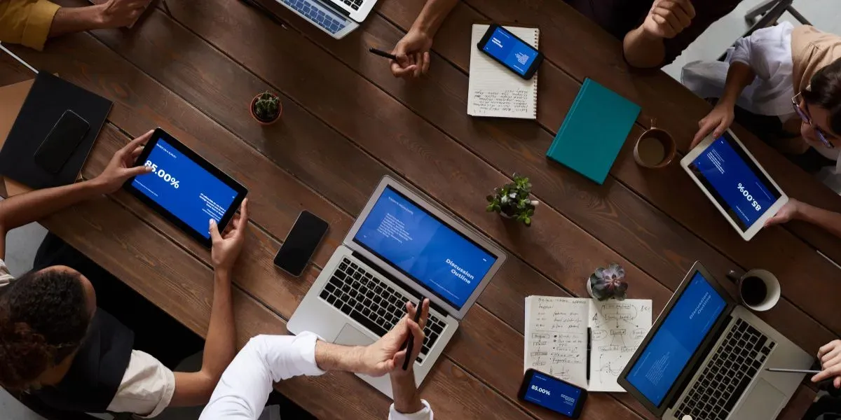 pessoas com computadores em uma mesa discutindo sobre mediação de conflitos
