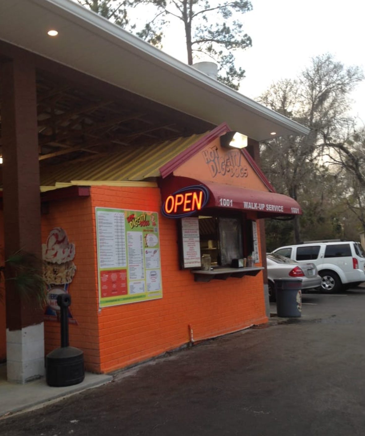 Orange takeout restaurant with an open sign and menu visible. Drive-up entrance.