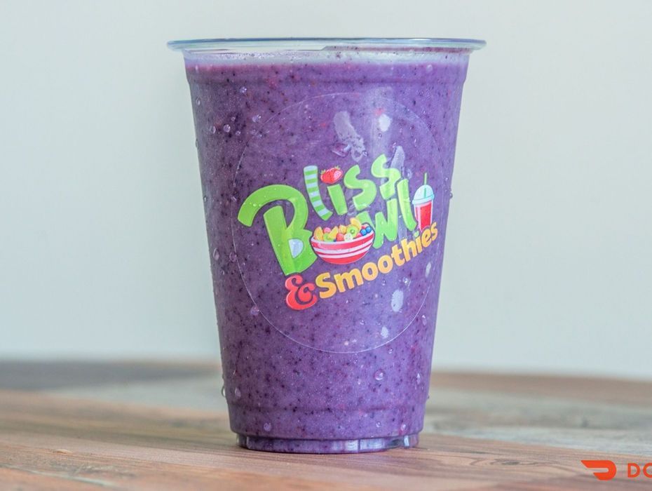 Purple smoothie cup with a colorful “Blissful Smoothie” logo on a wooden surface