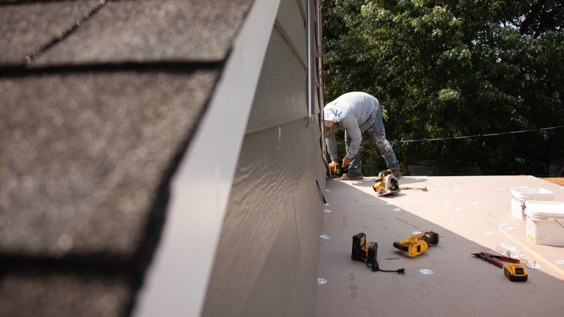 An image of a RETEX crew member installing a TPO flat roof on a Richmond VA home's addition.