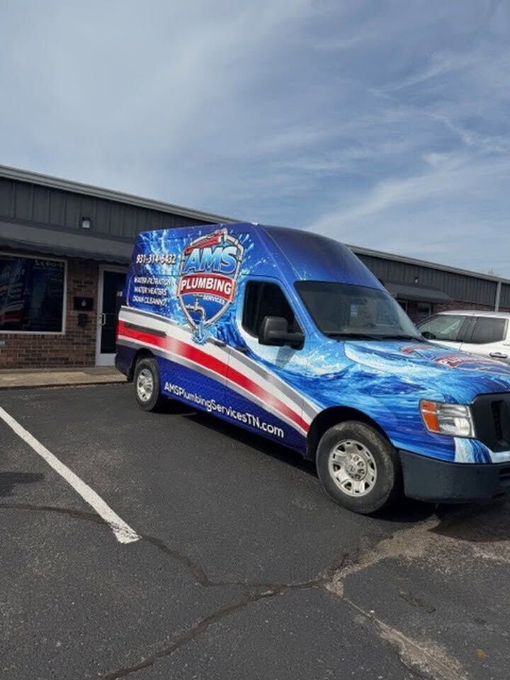 Blue and red branded van parked outside a building on a cloudy day