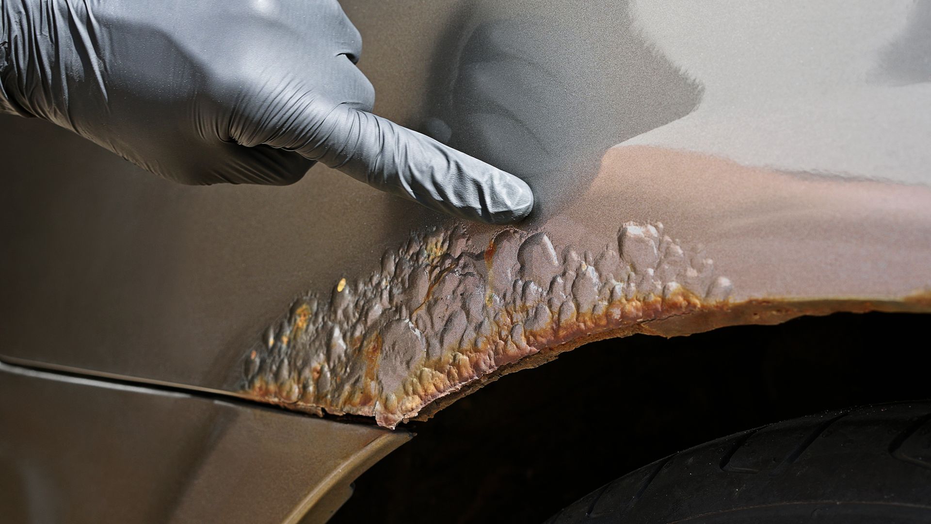 Severe automotive rust on a car wheel arch panel. Severe automotive rust on a car wheel arch panel.