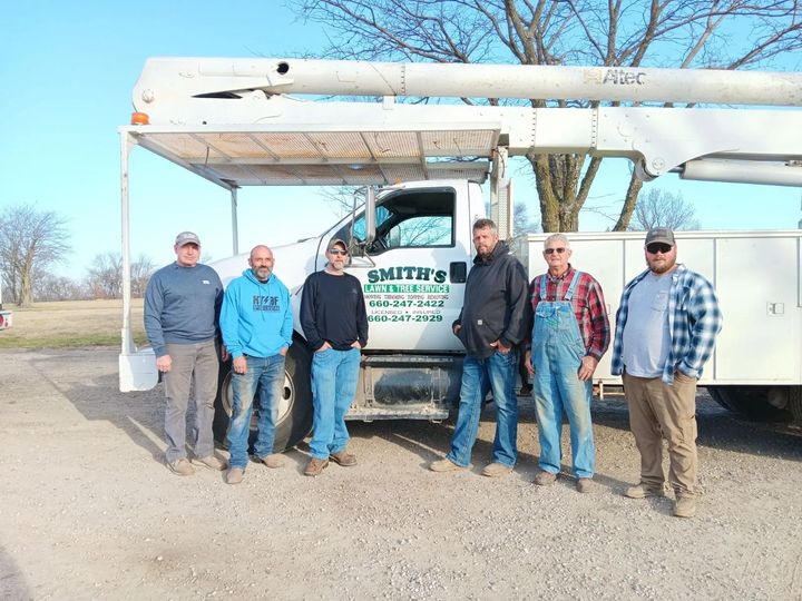A group of men are standing in front of a utility truck.