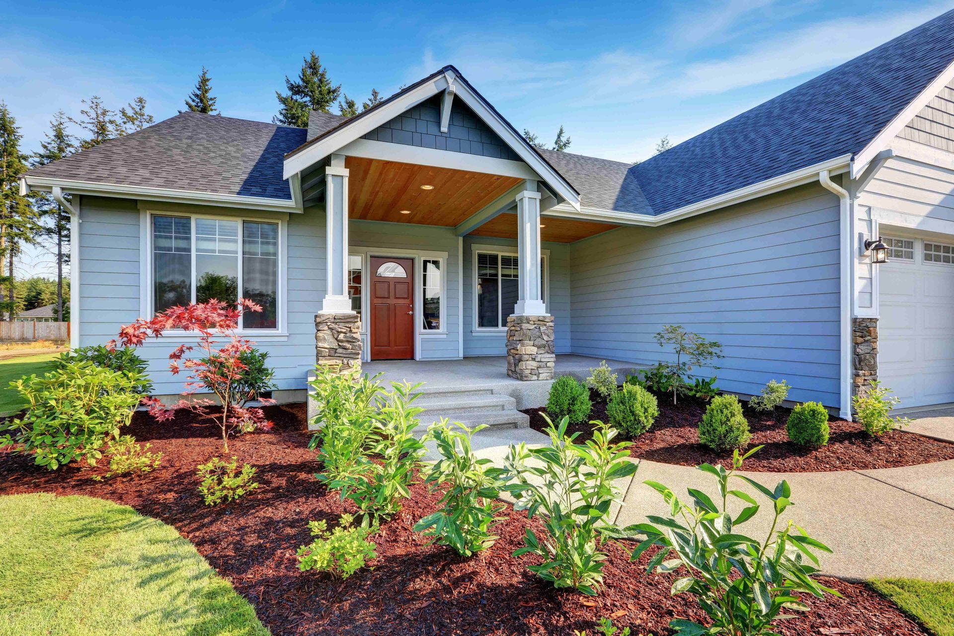 a blue house with a porch and a walkway in front of it