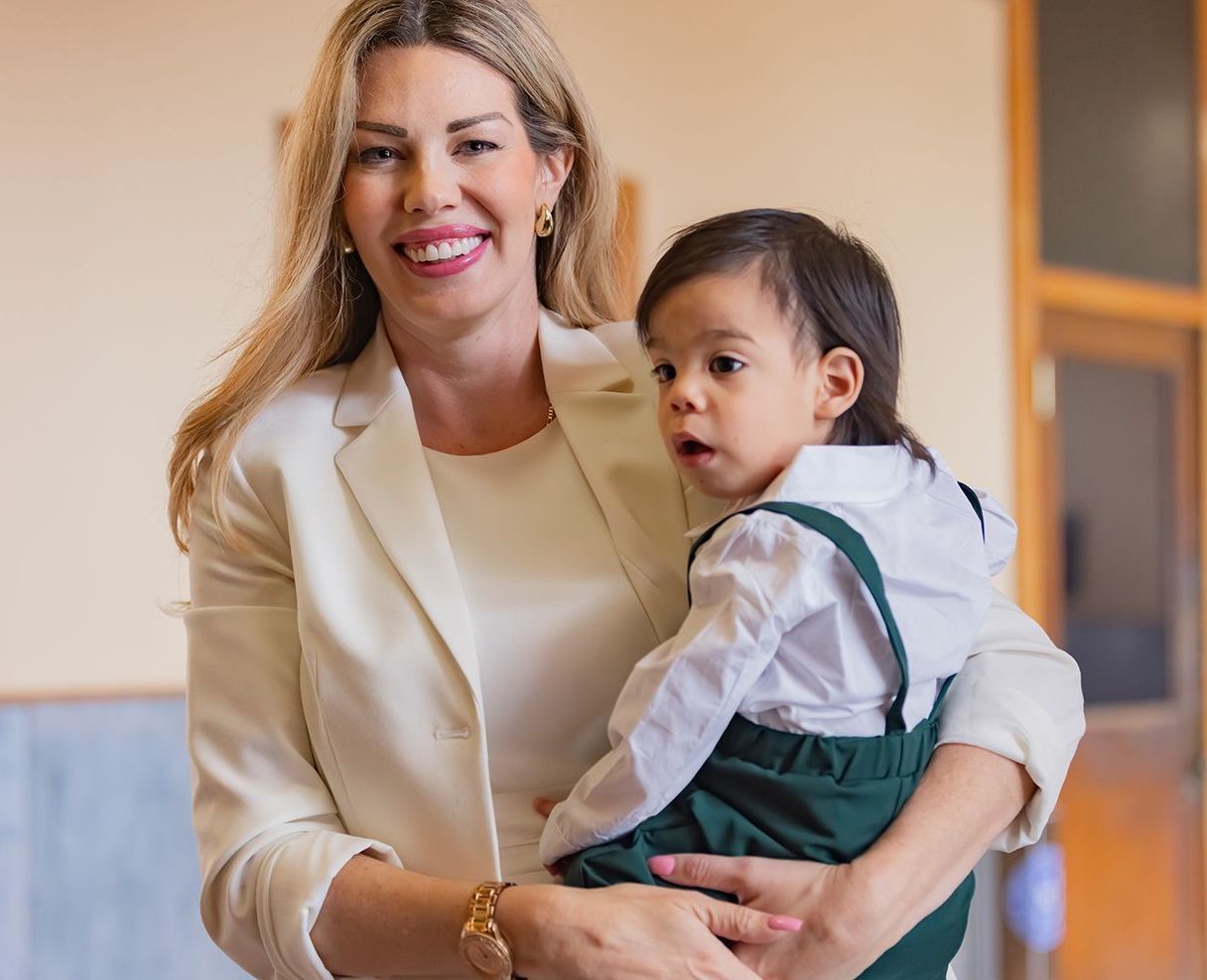 CASA Volunteer advocate holding child at court adoption, symbolizing care and support.