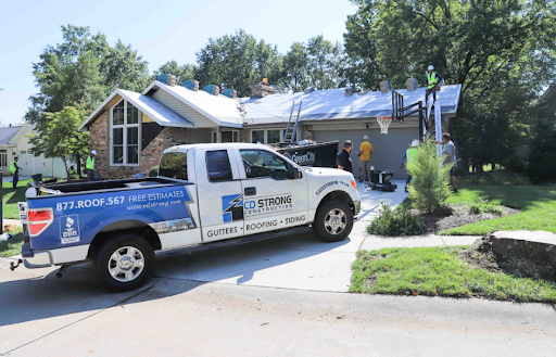CD Construction truck outside a home during a roof installation