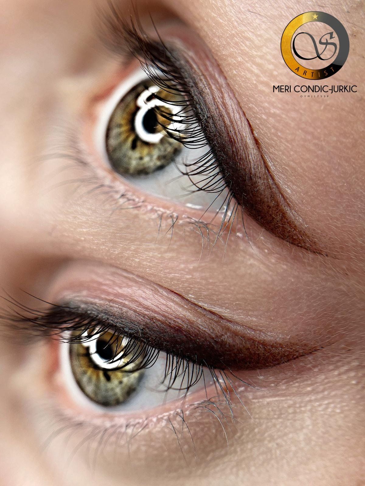 Nahaufnahme von zwei haselnussbraunen Augen mit schimmerndem Make-up und langen Wimpern, eines davon mit einem Schönheitsfleck in der Nähe der Augenbraue.