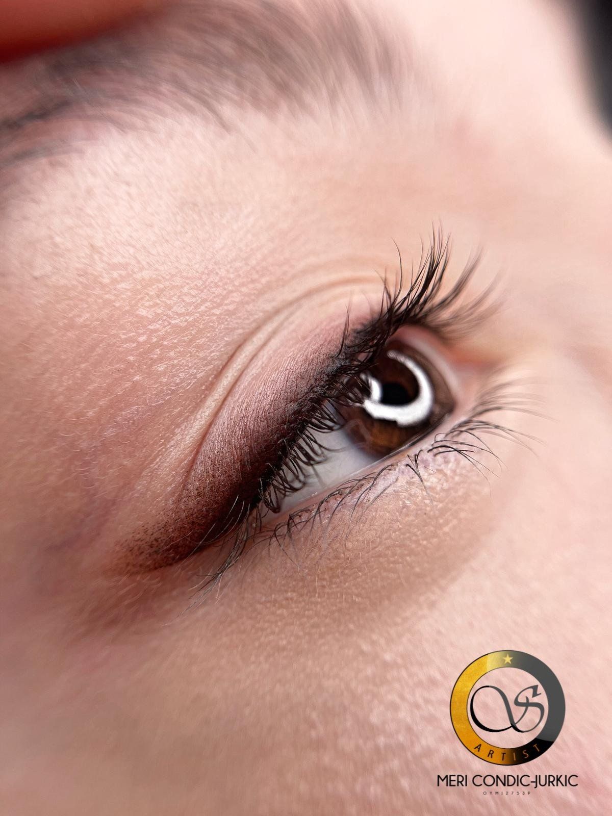 Nahaufnahme eines braunen Auges mit langen Wimpern und einem zarten beigen Augen-Make-up