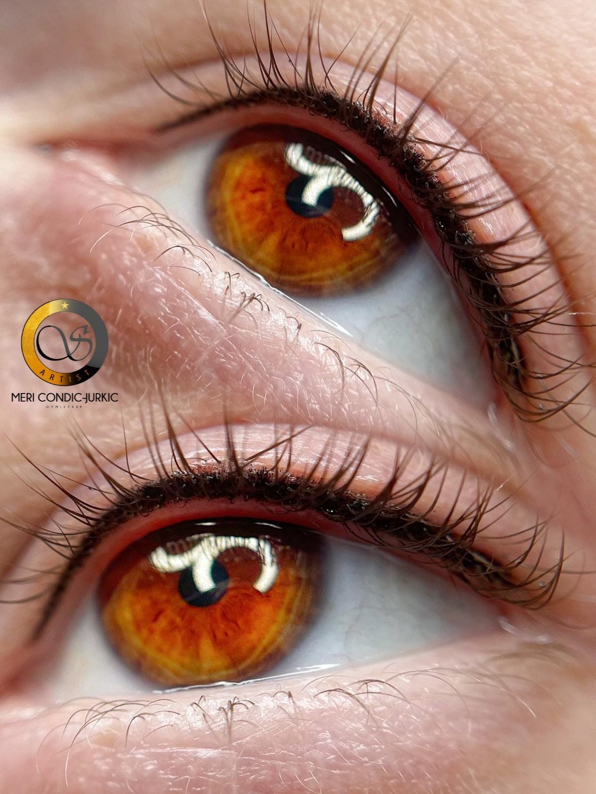 Nahaufnahme von zwei bernsteinbraunen Augen mit langen Wimpern und glänzenden Reflexen.