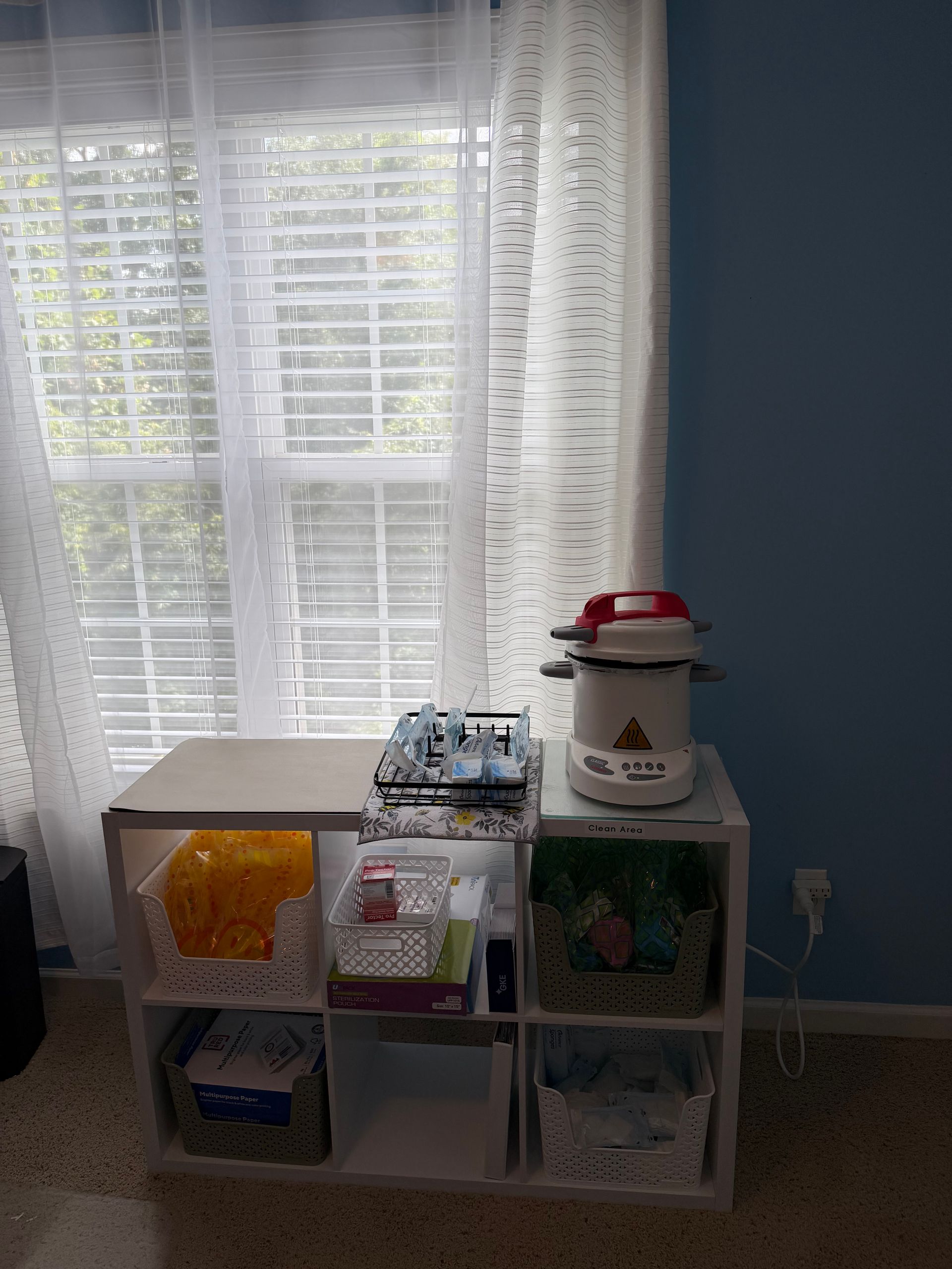 Cube storage shelves with toys under a bright window and sheer white curtains