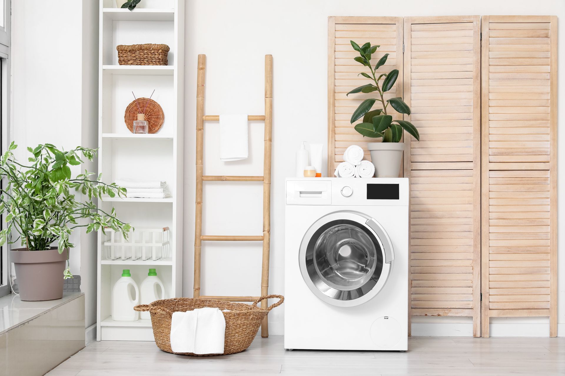 Bright laundry room with a white front-load washer, wicker basket, and wood folding screen.