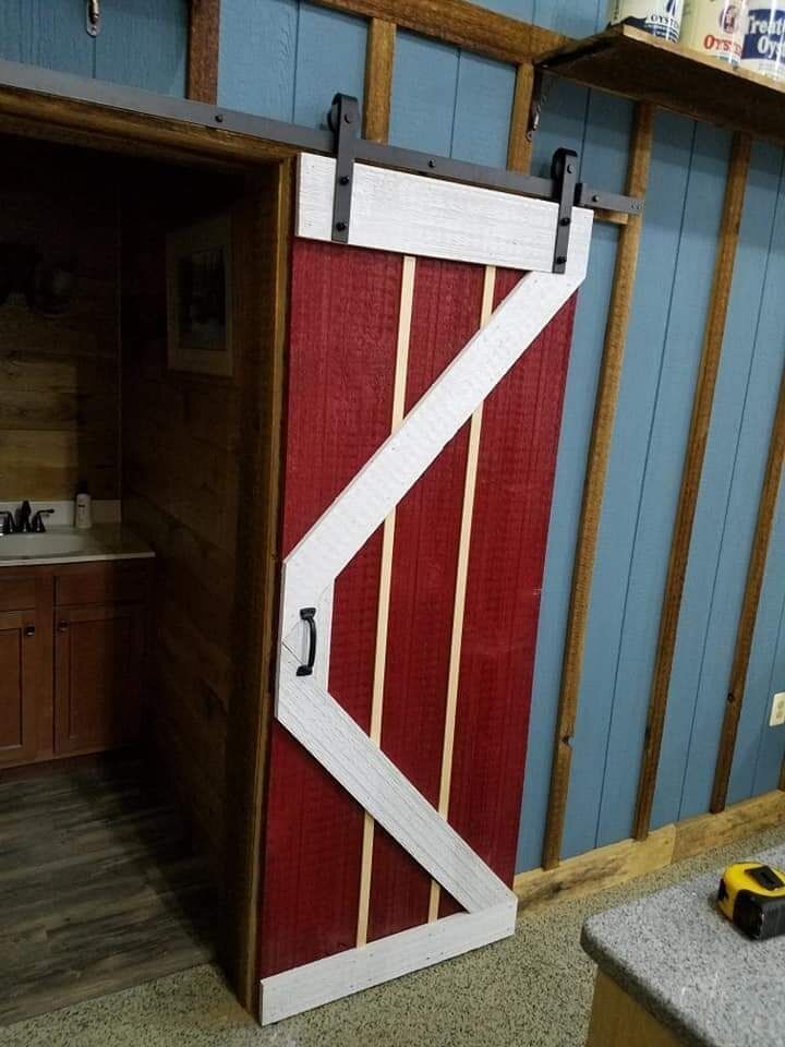 A red and white sliding barn door is in a room.