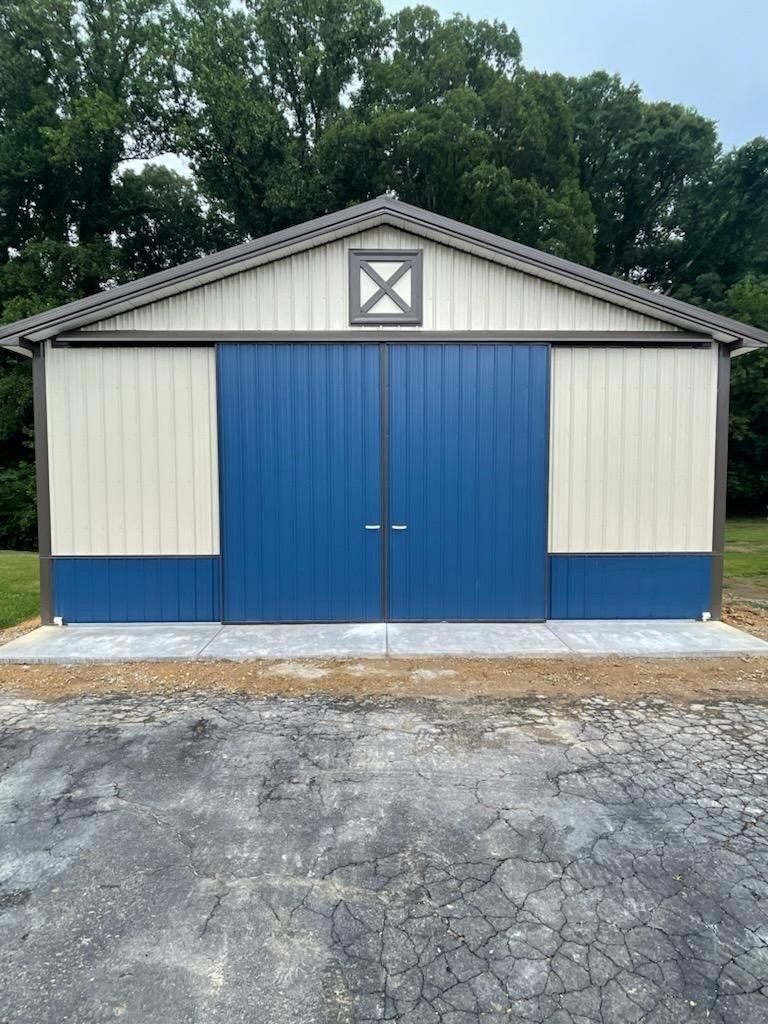 A blue and white barn with a sliding door