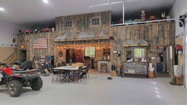 A man is riding a four wheeler in a garage.