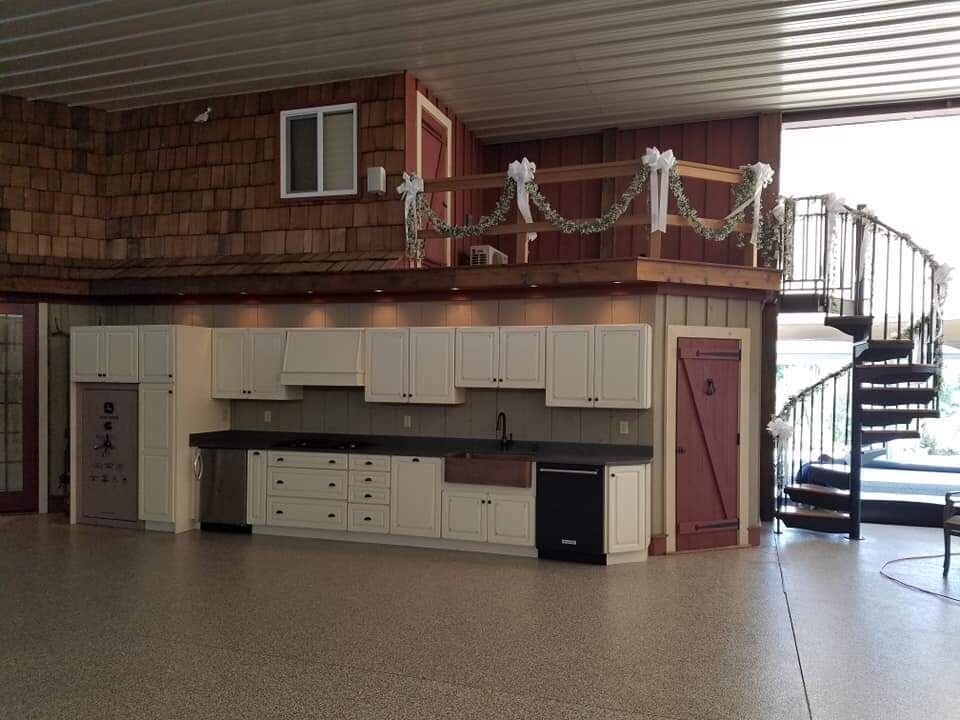 An empty kitchen with white cabinets and a staircase