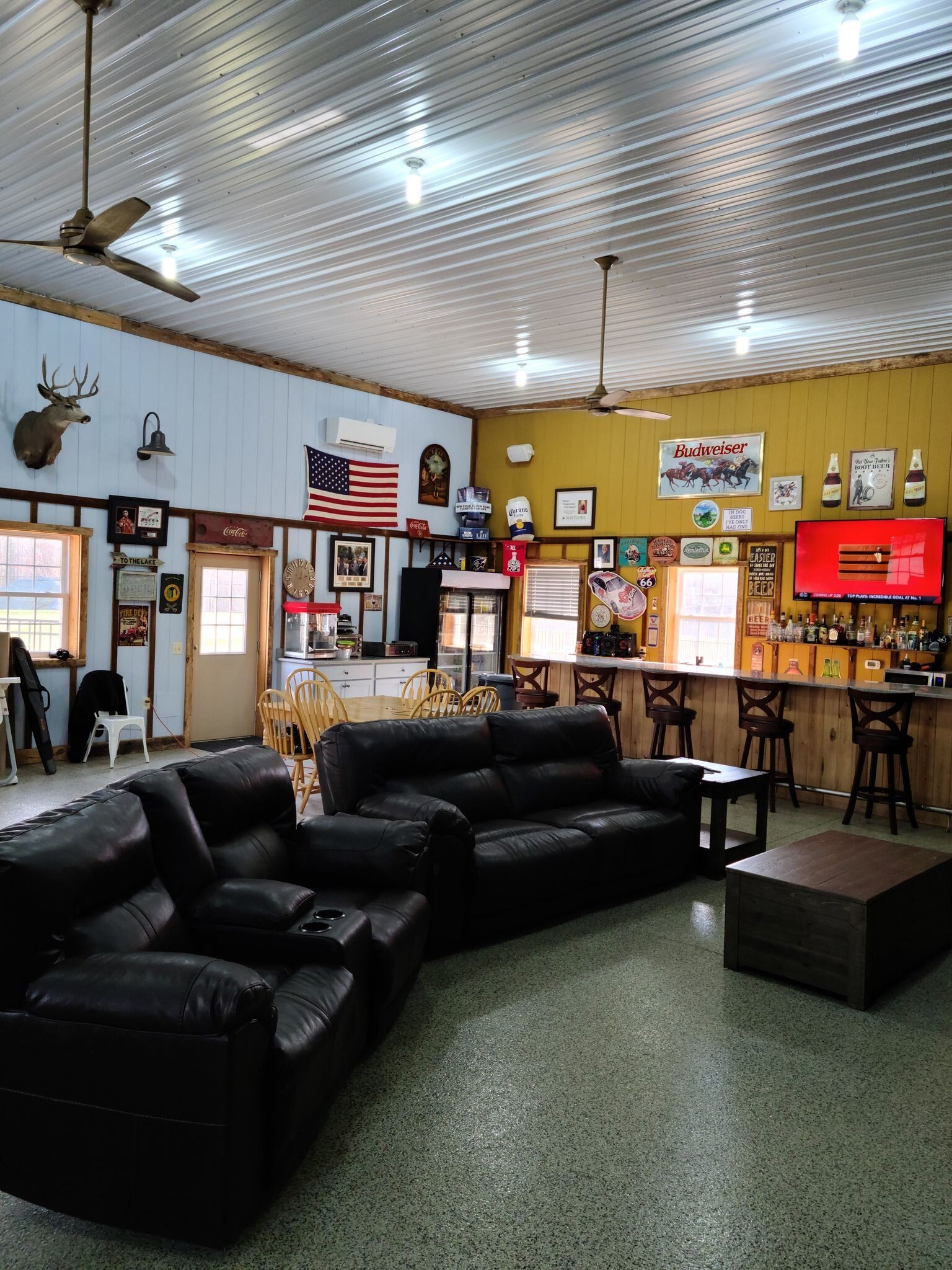 A living room with a couch and chairs and a bar