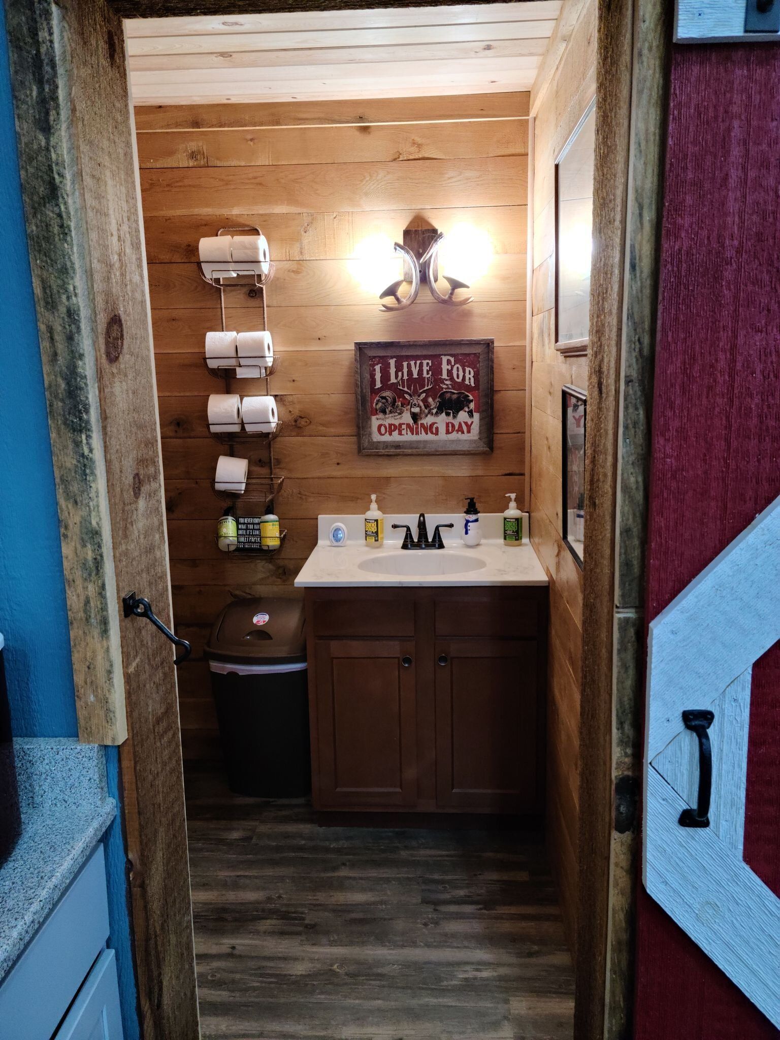 A bathroom with a sink and toilet paper hanging on the wall.