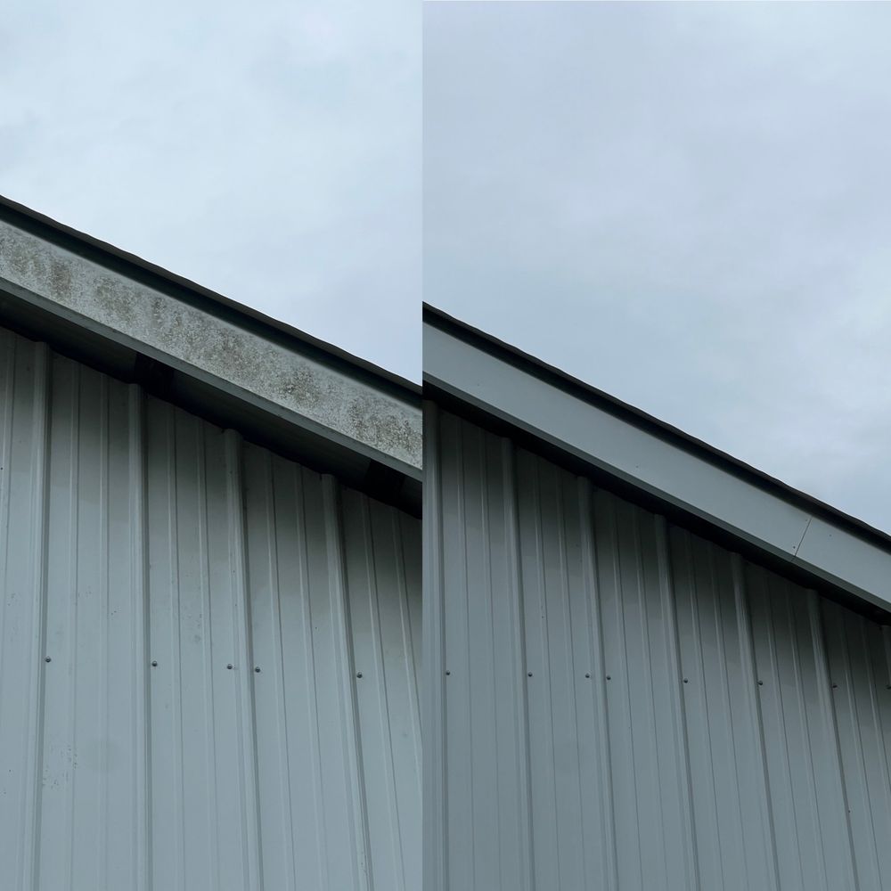 Exterior of a gray metal building with a slanted roof against an overcast sky