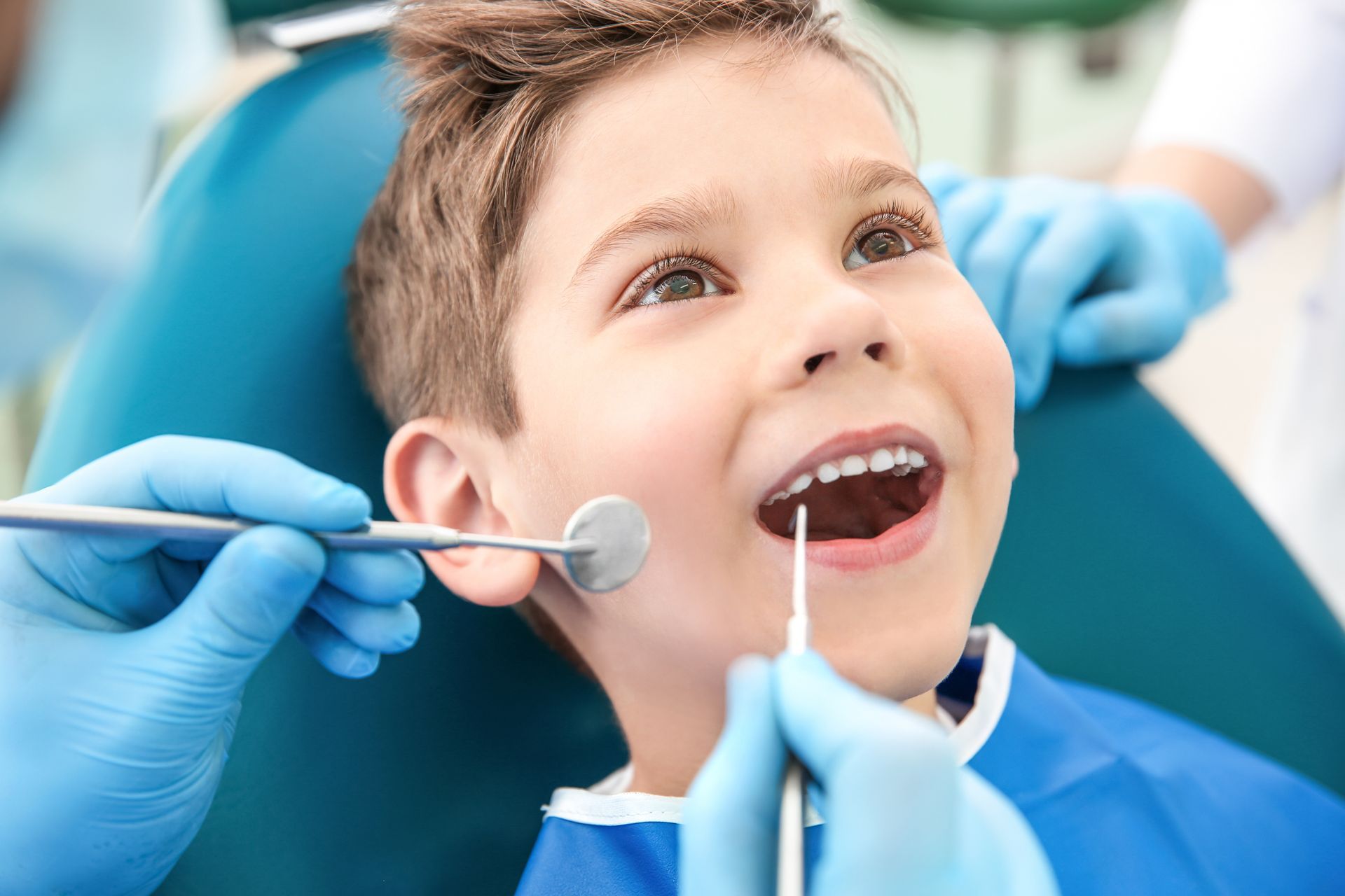 A dentist is examining a child's teeth.