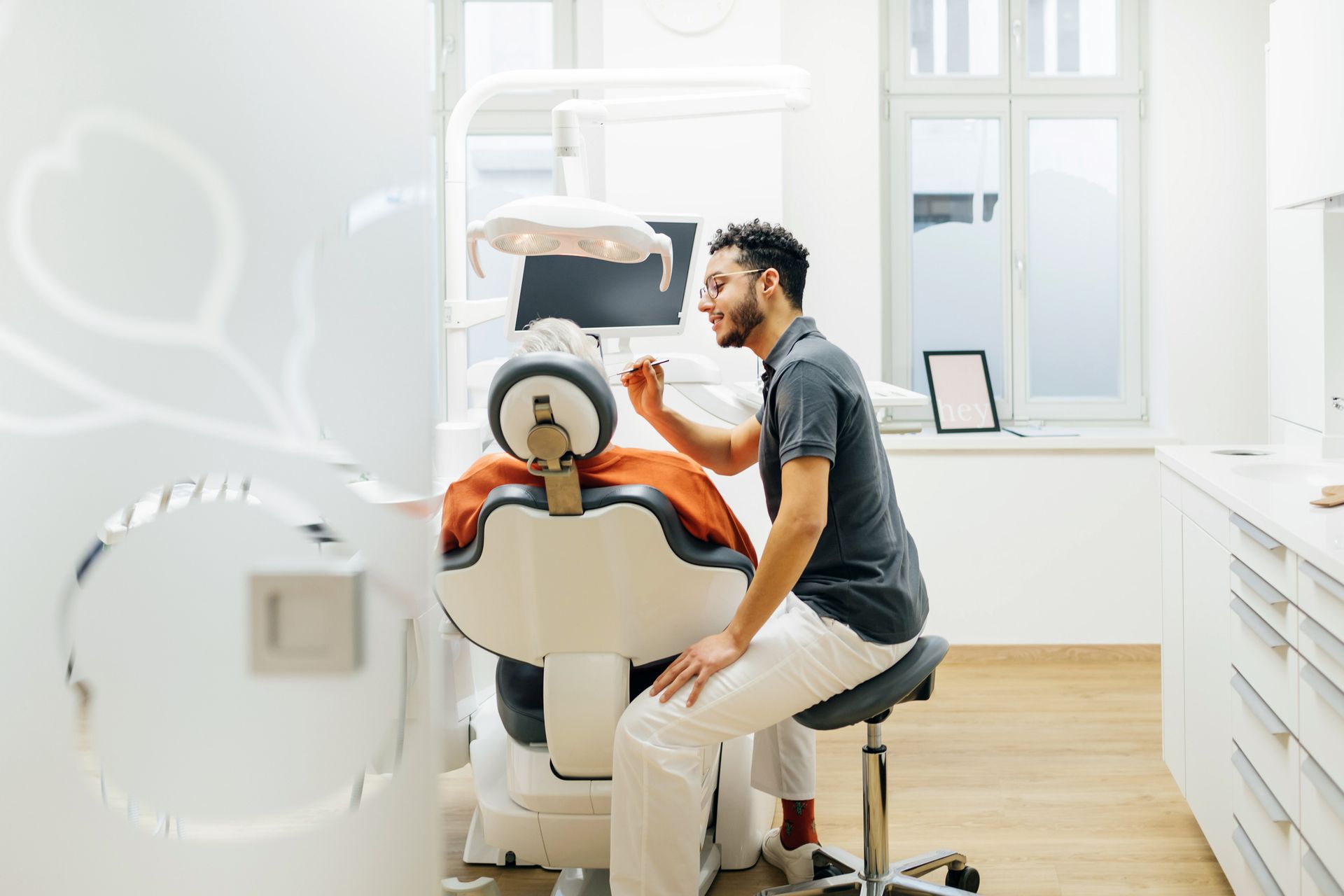 Dentist Leaning In While Tending To Patient In Surgery