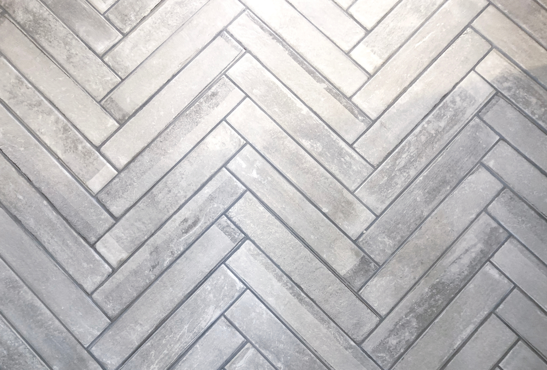 A close up of a herringbone pattern on a tile floor.