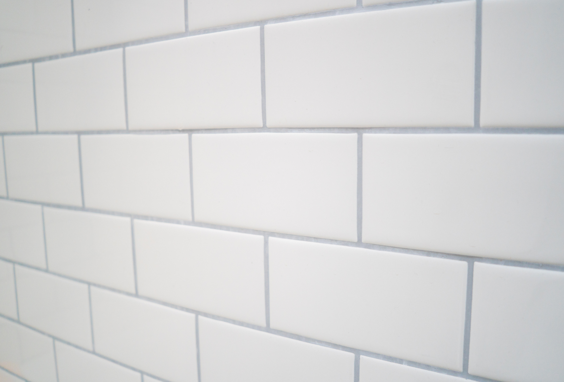 A close up of a white subway tile wall.