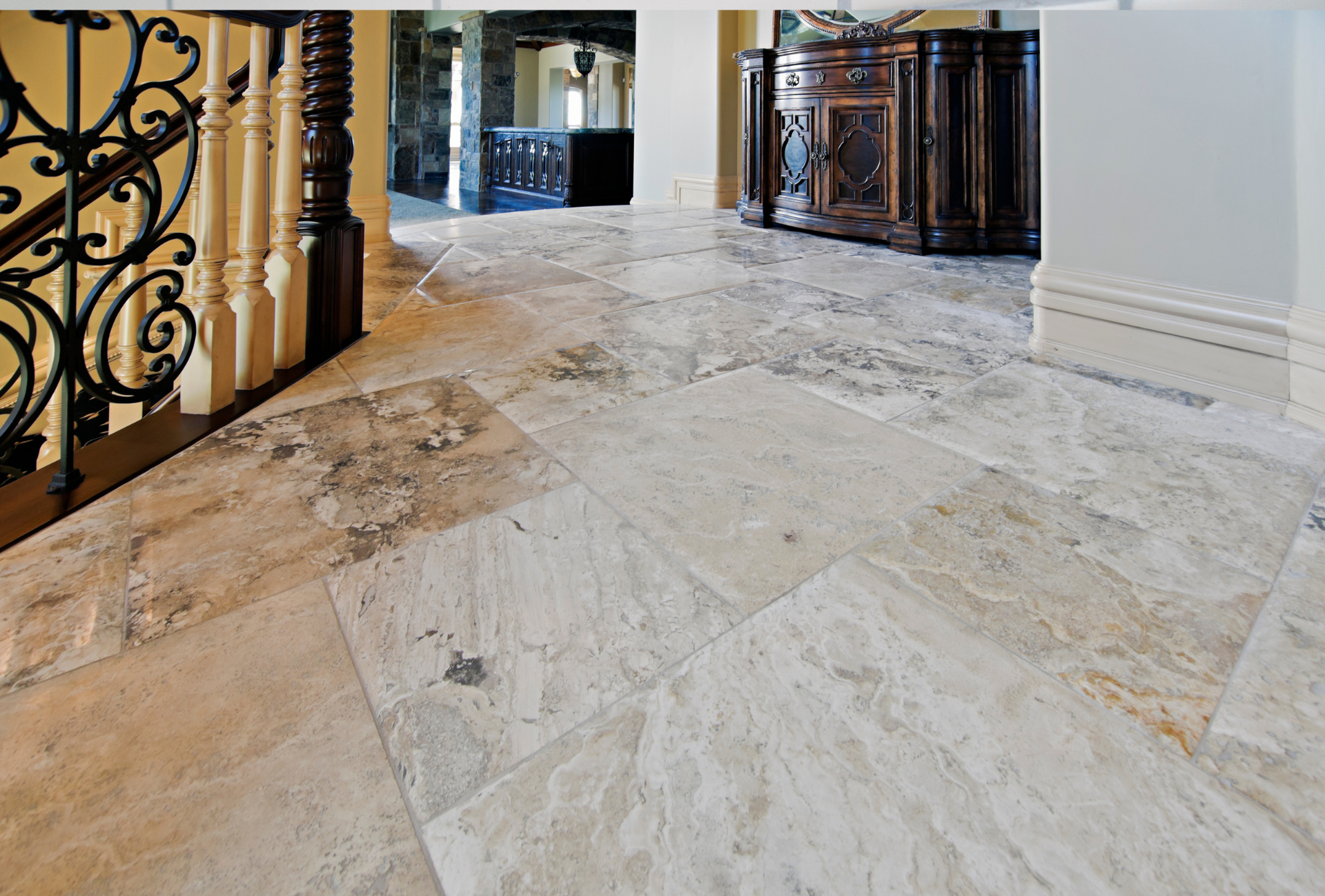 A marble floor with a wrought iron railing in the background